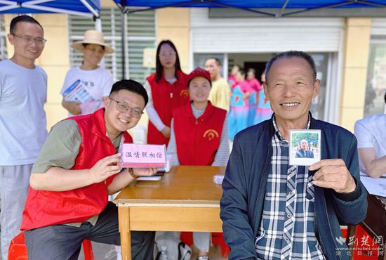 “溫情照相館”攤位上，前來照相的老人與志愿者開心地合影留念_副本.jpg